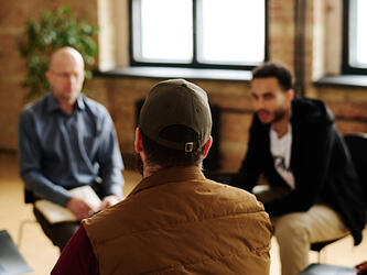 men talking in peer support group